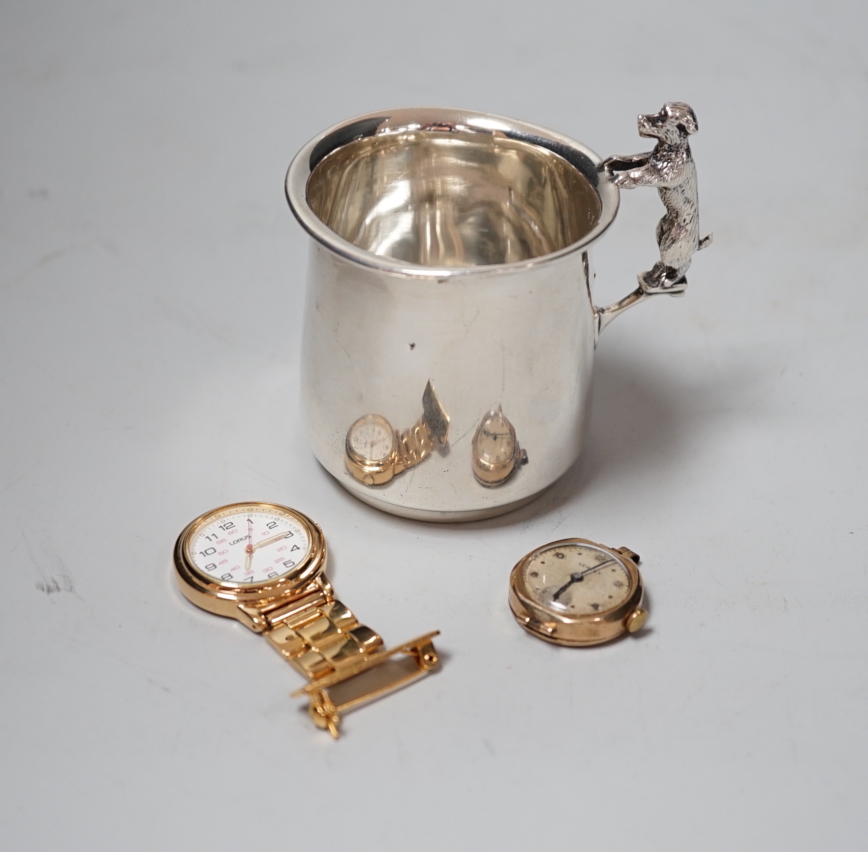 A George V silver christening mug, with dog handle, Sanders & Mackenzie, Birmingham, 1931, 77mm, together with a lady's 9ct gold Vertex manual wind wrist watch, no strap and a Lorus nurses watch.